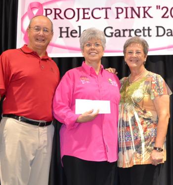 Chairperson Theresa Prather, center, accepts a donation from the Helen Blue Garrett family, represented by Tommy Garrett, left, and Jearayne Mehal, right, son and daughter of the 2013 honoree.